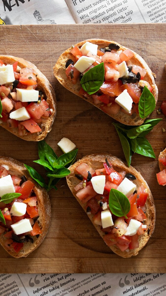 sliced tomato and green vegetable on brown wooden chopping board
