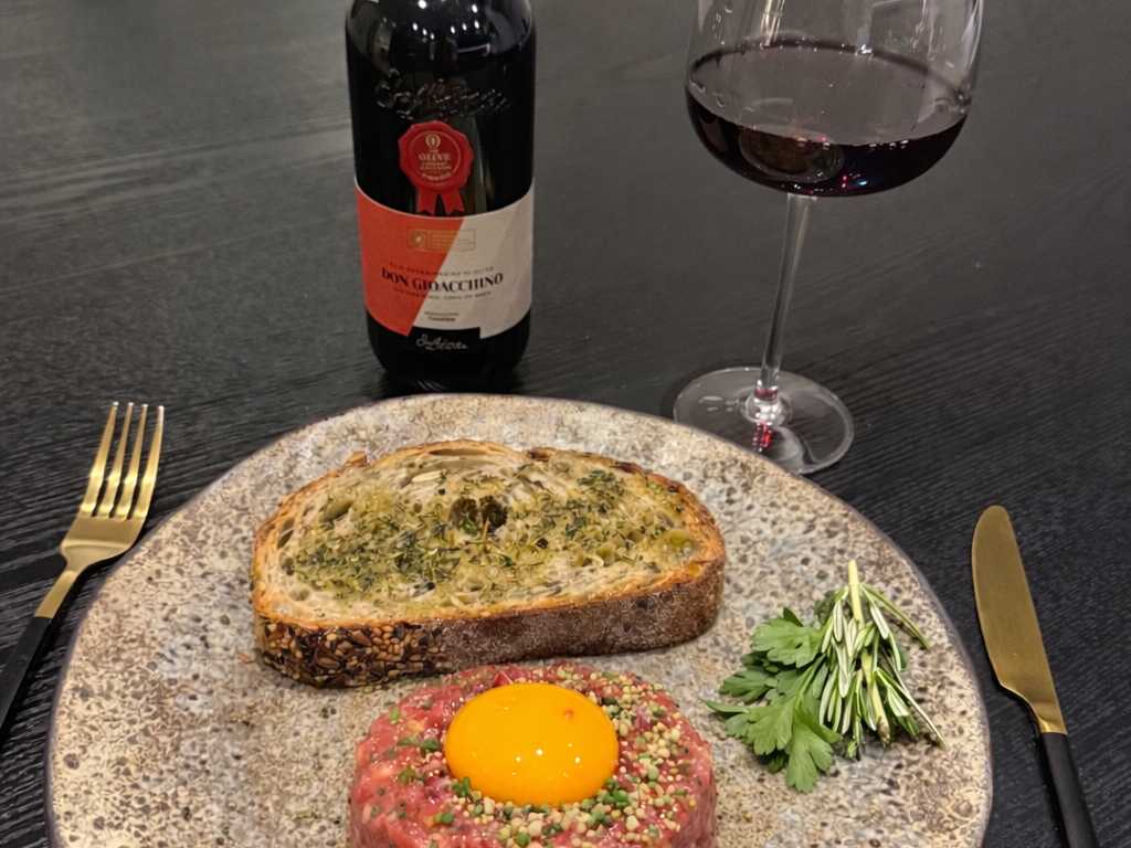 Beef tartare with olive oil croutons, topped with an egg yolk